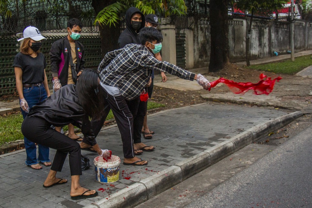 Anti-coup protesters throw red paint on a street during a demonstration in Yangon on Tuesday. Photo: AP