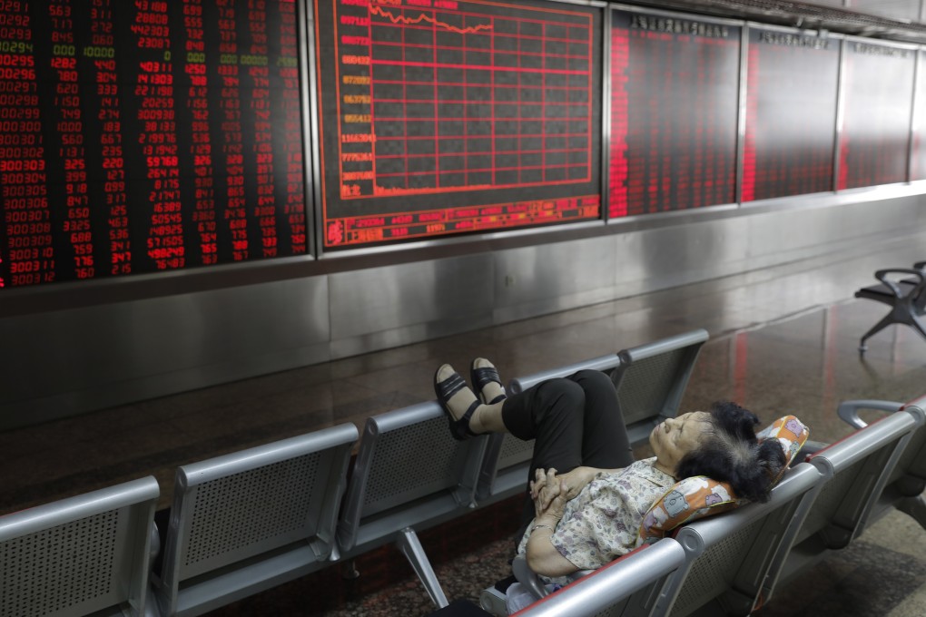 An investor takes a nap in front of an electronic board showing stock prices at a securities brokerage in Beijing in June 2019. Photo: EPA-EFE