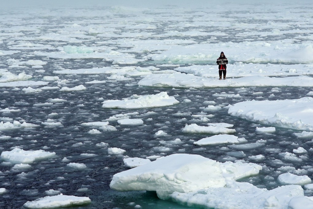 Environmental activist and campaigner Mya-Rose Craig holds a cardboard sign reading “youth strike for climate” while standing on the ice floe in the middle of the Arctic Ocean, hundreds of miles above the Arctic Circle, on September 20, 2020. Photo: Reuters