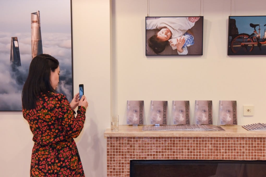 A visitor snaps an image of exhibits at the show of women’s photography “Through Her Eyes: Stories of the City by Four Female Photographers” in Shanghai. Photo: Space33