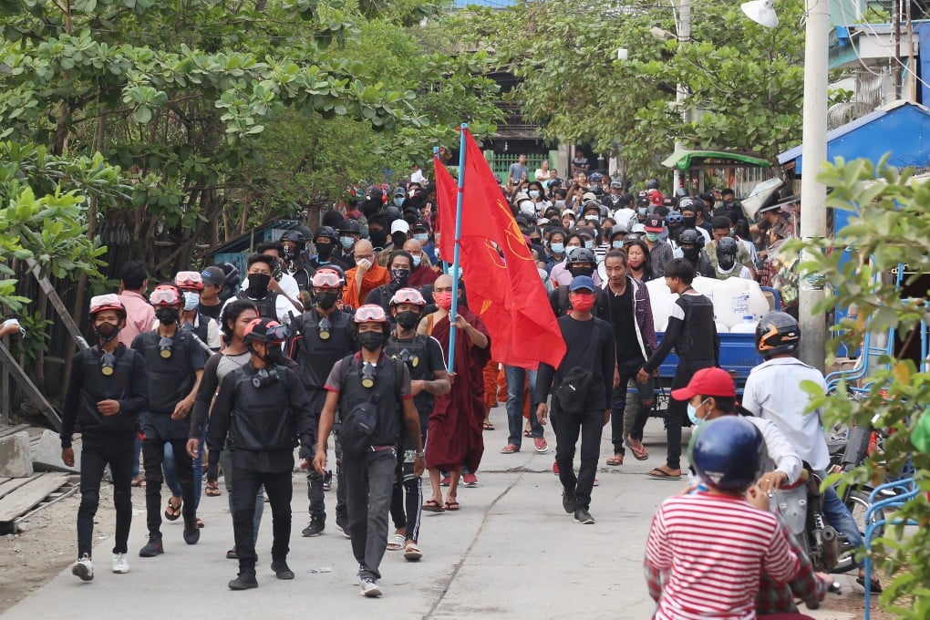 Demonstrators march during a protest in Mandalay. Business activity in Myanmar has plummeted since the coup. Photo: EPA-EFE