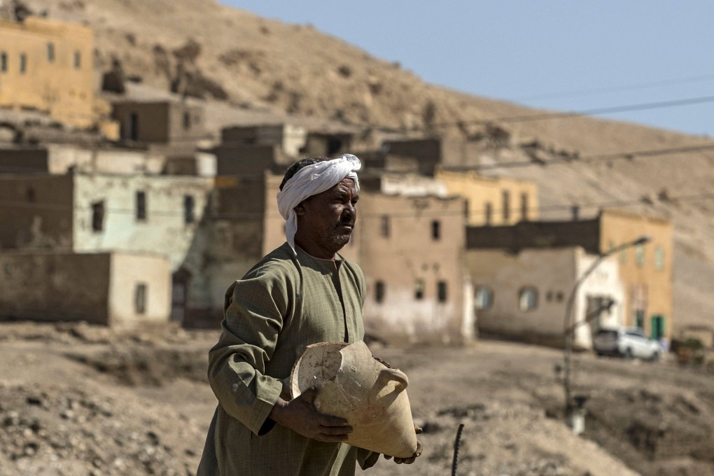 A worker carries a pot at the archaeological site of a 3,000-year-old city near Luxor, Egypt on Saturday. Photo: AFP