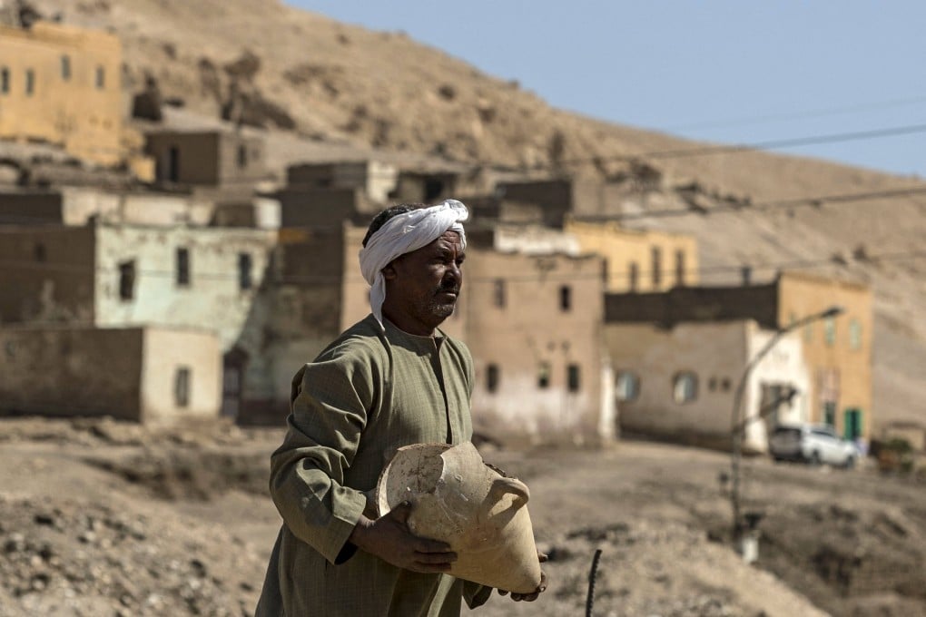 A worker carries a pot at the archaeological site of a 3,000-year-old city near Luxor, Egypt on Saturday. Photo: AFP