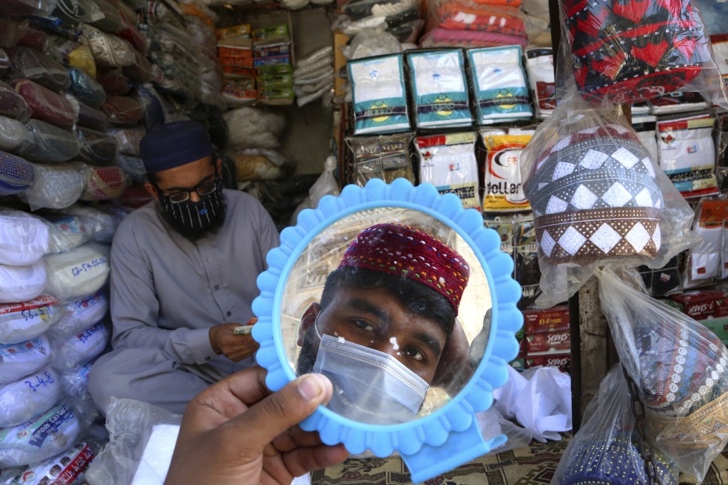 A man in Peshawar, Pakistan tries on a traditional cap in preparation for Ramadan. Photo: AP