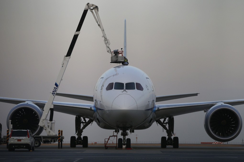 A mechanic of works atop an All Nippon Airways plane. Photo: Reuters