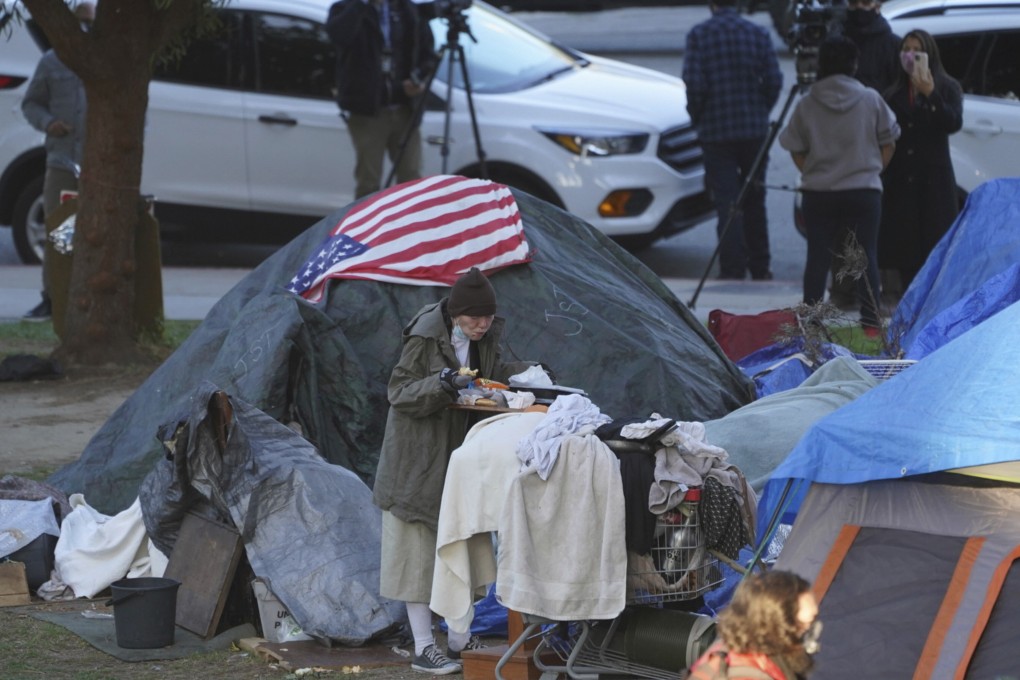 A woman eats outside her tent at the Echo Park encampment at Echo Park Lake in Los Angeles on March 24. As Fed chair Jerome Powell said recently, “...even though some parts of the [US] economy are just doing great, there’s a very large group of people who are not”. Photo: AP