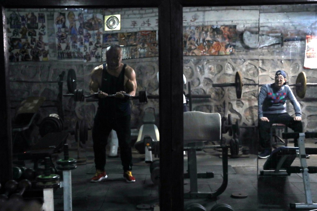 Former factory worker and current gym manager Xu Wei, 63, exercises with a self-made barbell. Photo: Reuters