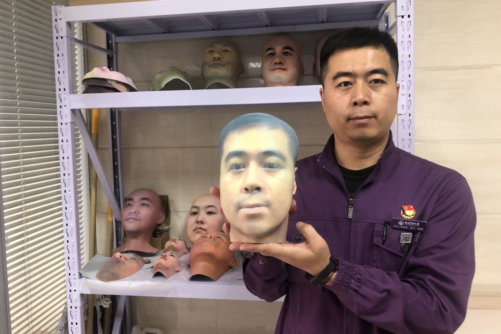 Zhang Lianchao, a staff member at the Xian Funeral Home, holds up a mask of his face printed using 3D printing technology. Photo: Zhang Lianchao