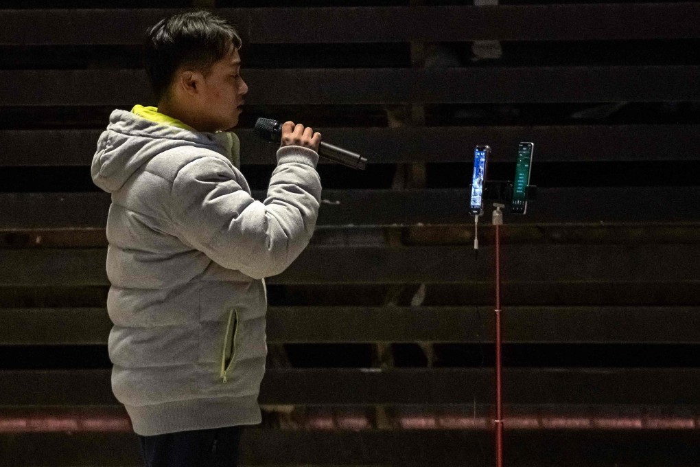 Retired champion athlete Zhang Shangwu sings in a Baoding car park in March, using an app and smartphones on a tripod to live-stream his performance. Photo: AFP