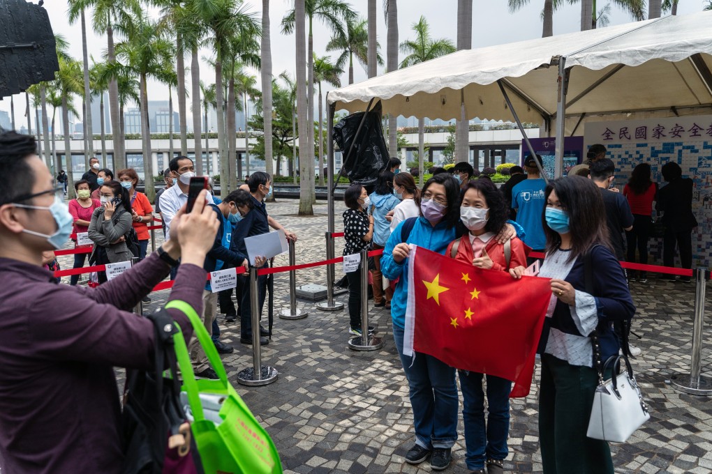 People pose with a Chinese flag during a visit to a National Security Education Day event on Thursday. Photo: Bloomberg