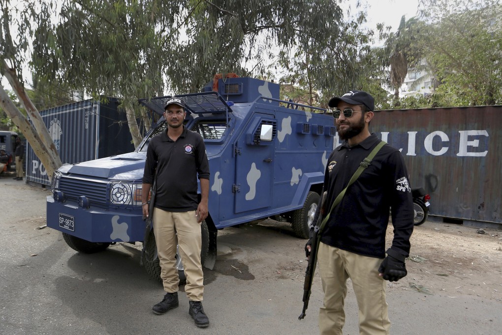 Police officers guard a road blocked with shipping containers, near the French consulate in Karachi, as France advised its nationals and companies to temporarily leave the country. Photo: AP