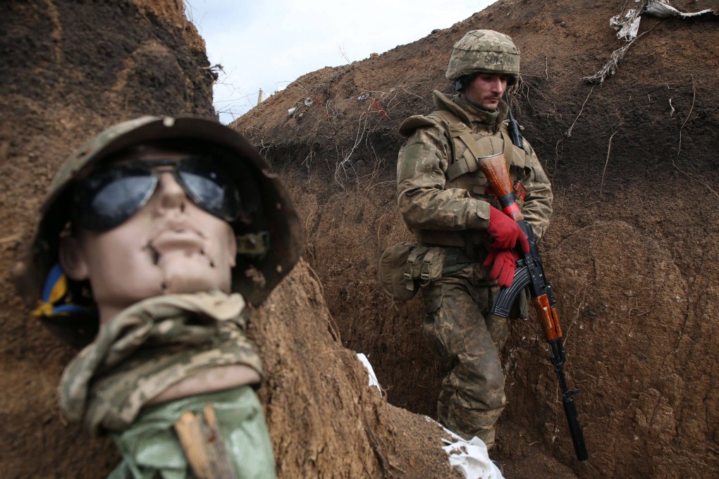 An Ukrainian soldier walks past a mannequin’s head in a trench on the frontline near the town of Zolote, eastern Luhansk region, Ukraine. Photo: AFP
