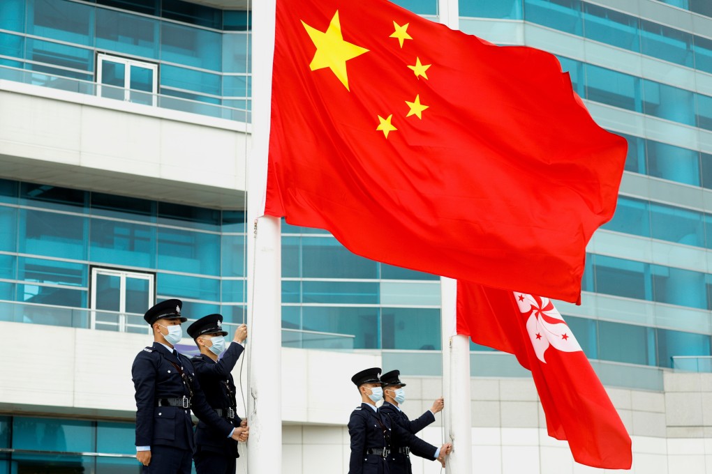 Police officers raise the Chinese and Hong Kong flags at Golden Bauhinia Square in Hong Kong on March 11. Photo: Reuters