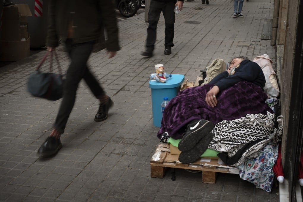 A homeless man is seen lying on the ground in Barcelona on Friday. Spain is one of the economies most vulnerable to long-term scarring from the pandemic, observers say. Photo: AP