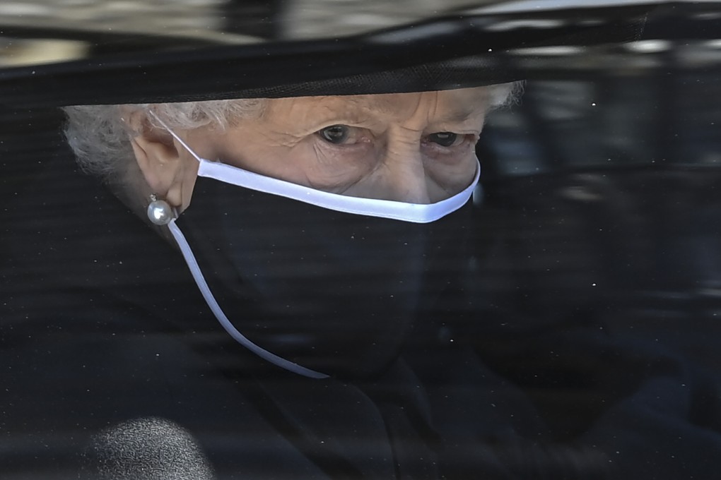 Britain’s Queen Elizabeth II follows her husband Prince Philip’s coffin in a car as it makes its way past the Round Tower during the funeral at Windsor Castle on Saturday. Photo: AP