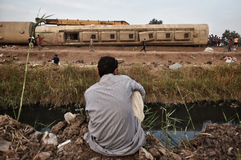 A man inspects the damaged wagons of a passenger train that derailed at the village of Sandahur near Banha in Qalyubia Governorate, Egypt. Photo: DPA