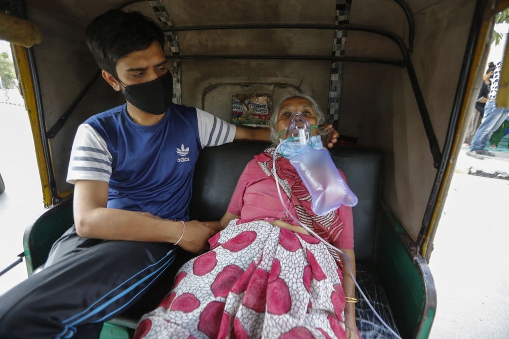 A Covid-19 patient wearing an oxygen mask waits inside an auto rickshaw to be admitted to hospital in Ahmedabad, India on Saturday. Photo: AP