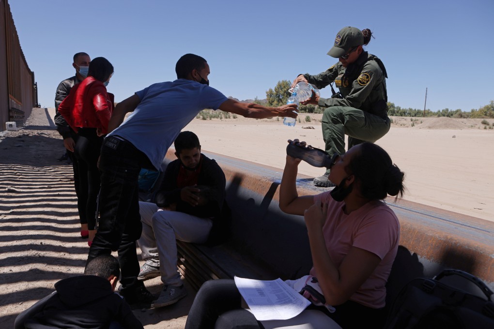 A US Border Patrol officer gives water to detained migrants  in Andrade, California who crossed into the United States from Mexico on Monday. Photo: Reuters
