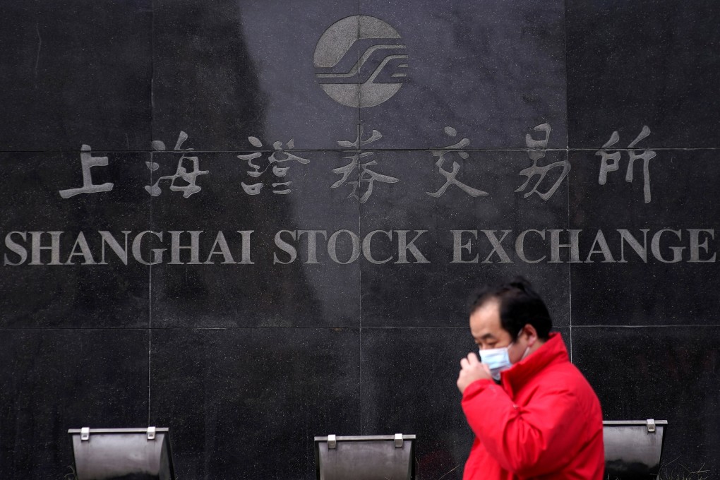 A man wearing a mask walks by the Shanghai Stock Exchange building at the Pudong financial district. Photo: Reuters
