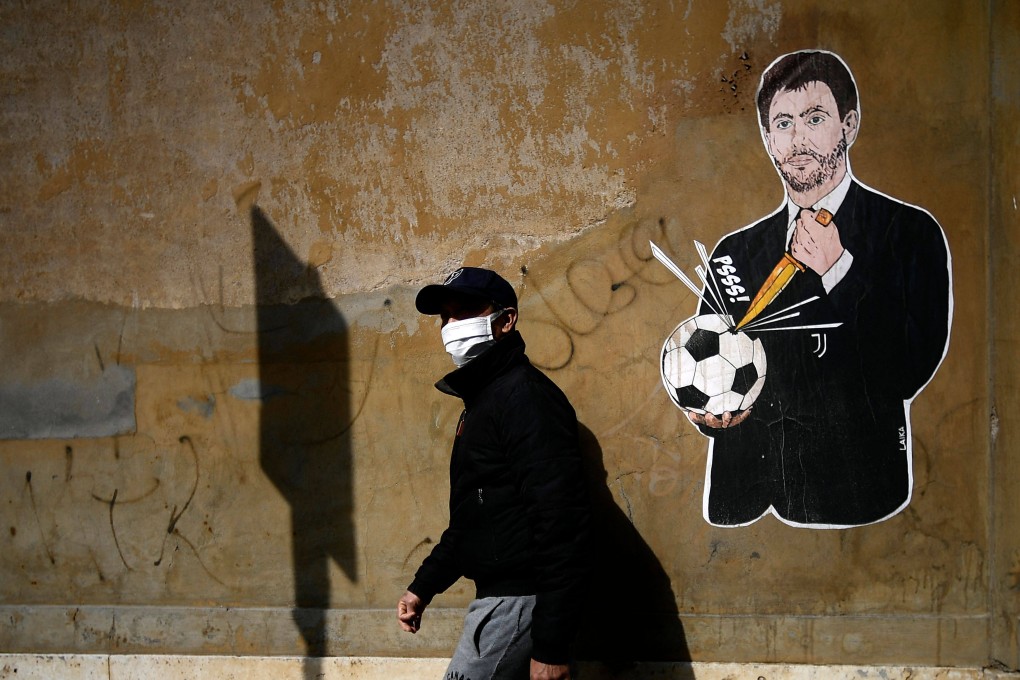 A man walks past graffiti showing Juventus president Andrea Agnelli puncturing a football, near the headquarters of the Italian Football Federation in Rome, on April 21. Italian champions Juventus were one of the driving forces behind the proposed European Super League. Photo: AFP