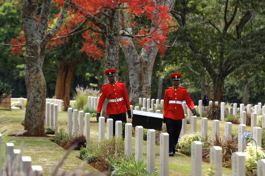 Two members of Kenya’s Military Police walk past graves after attending a remembrance service. Photo: AP