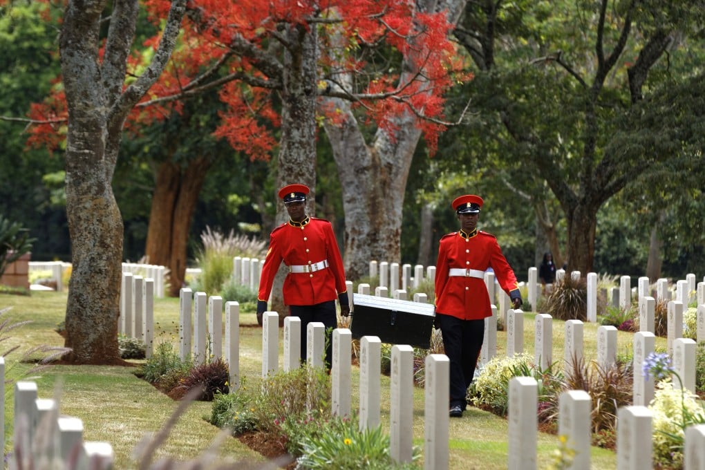 Two members of Kenya’s Military Police walk past graves after attending a remembrance service. Photo: AP