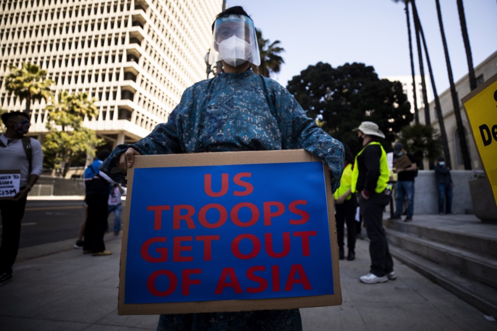 A demonstrator holds a poster as people gather for a protest against Asian racism, in Los Angeles, California, on March 27. It took place following the death of eight people, including six women of Asian descent, killed during a shooting spree in Atlanta on March 16. Photo:  EPA-EFE