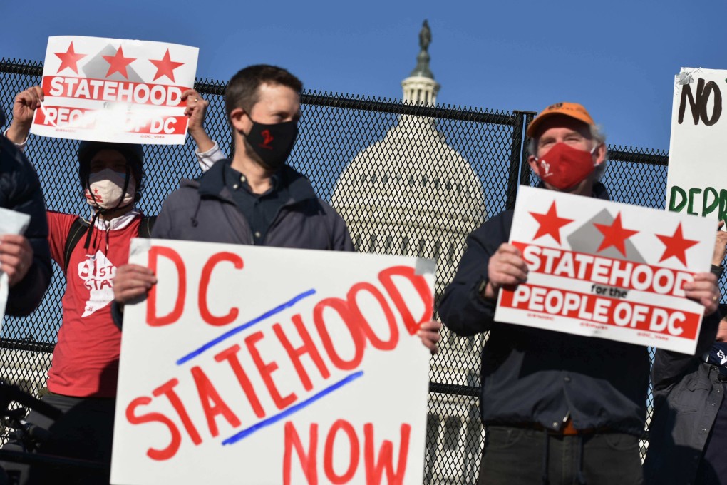 Activists hold signs as they take part in a rally in support of DC statehood near the US Capitol in March. Photo: AFP