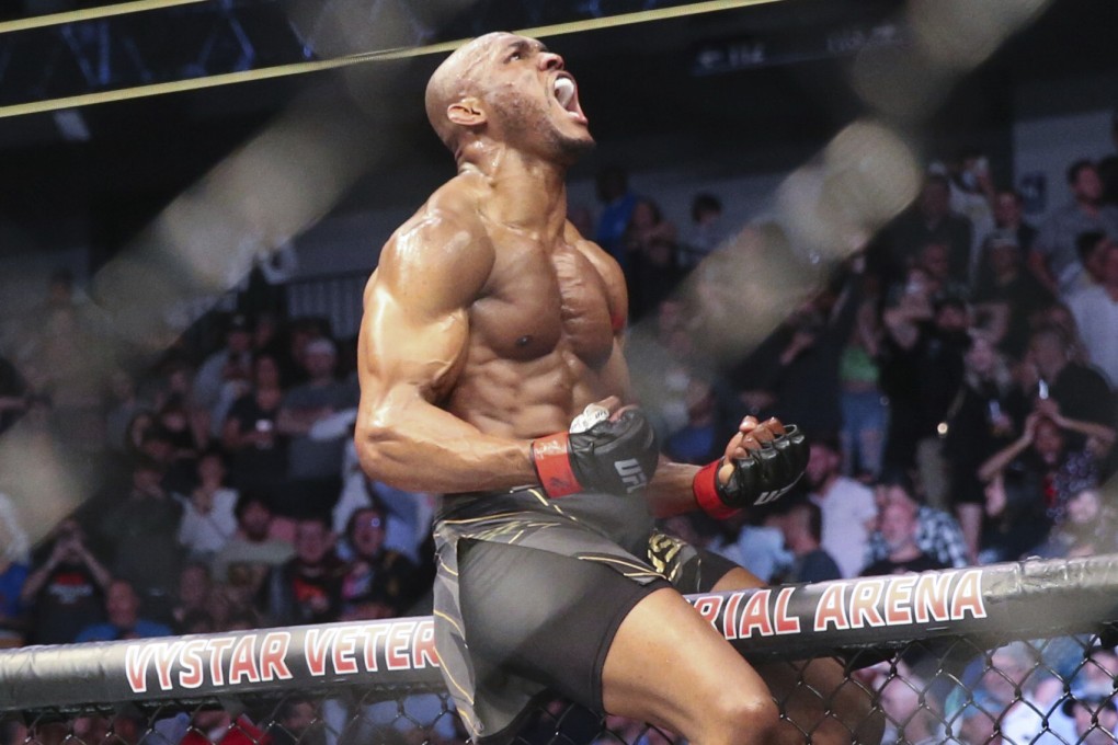 Kamaru Usman celebrates his win atop the Octagon fence after stopping Jorge Masvidal at UFC 261. Photo: AP