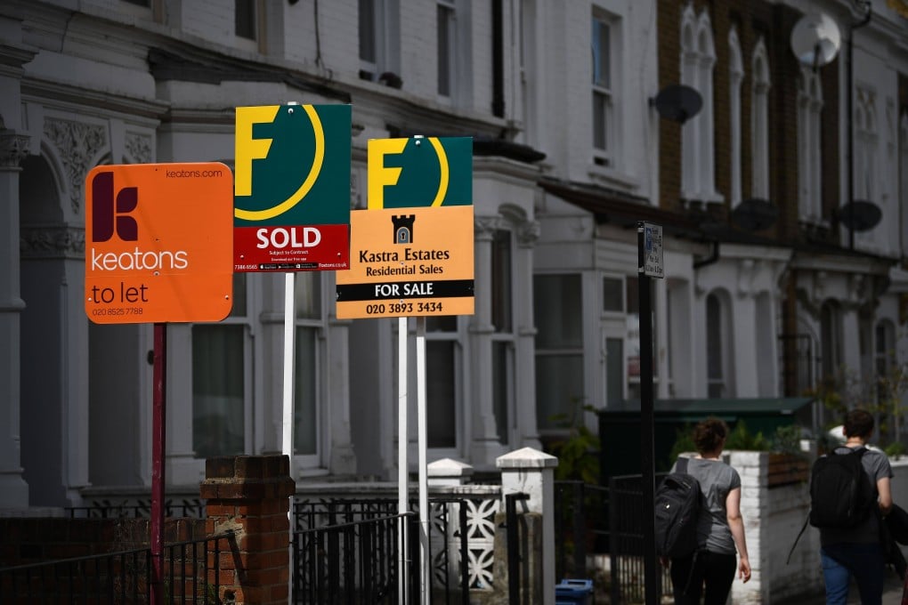 Property agents’ boards are pictured on a residential street in Hackney, east London. Photo: AFP
