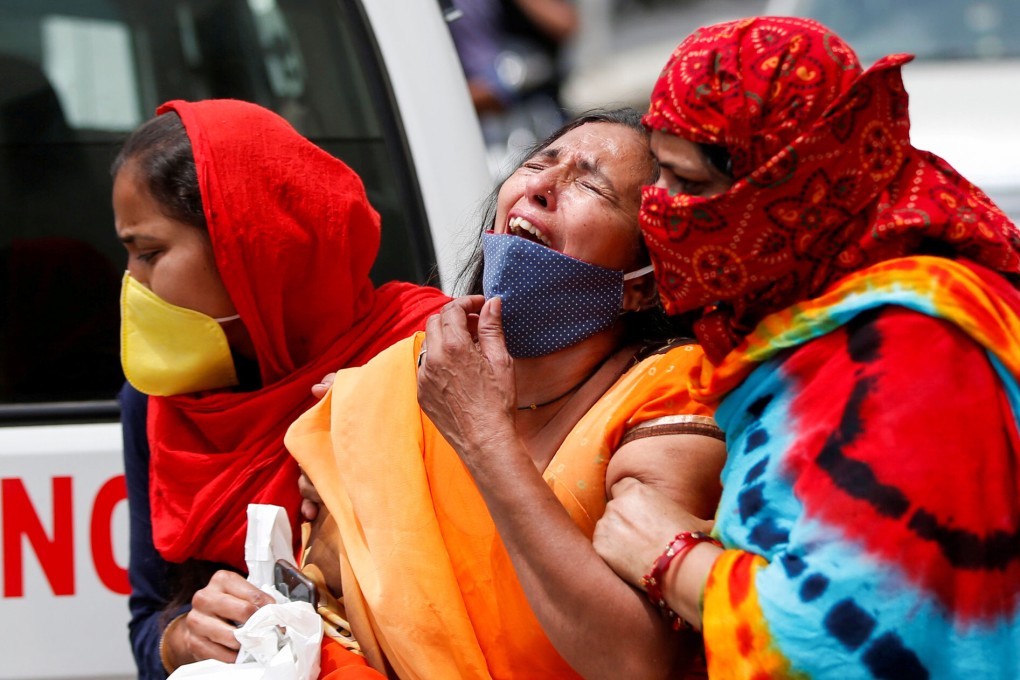 A woman is consoled after her husband died from Covid-19 in Ahmedabad, India. Photo: Reuters