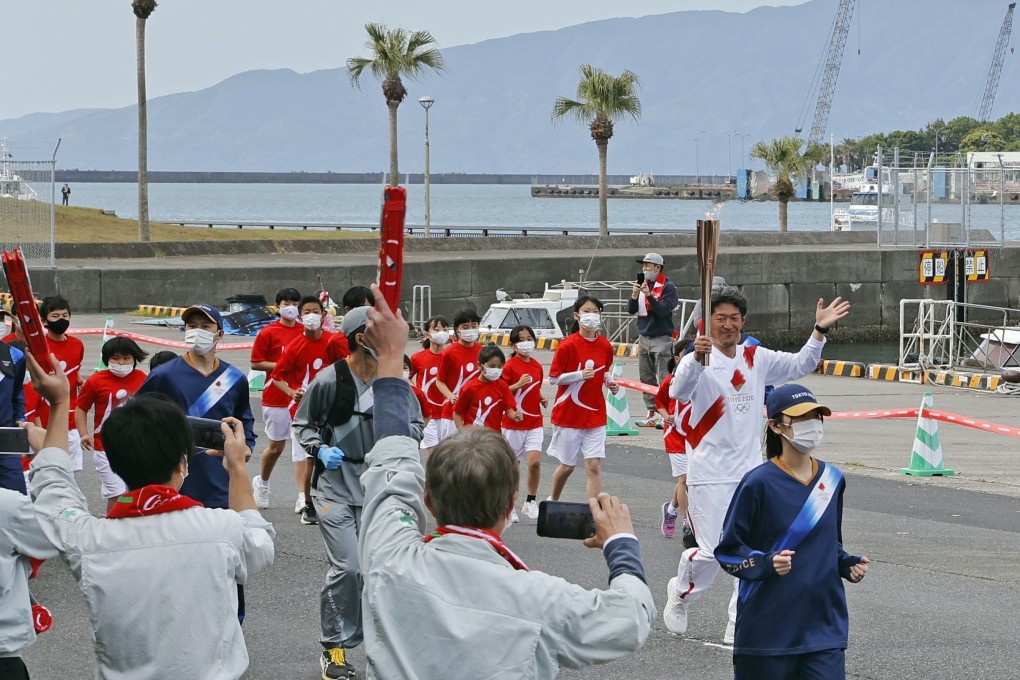 A Tokyo Olympic torch relay runner waves in Shibushi in Kagoshima prefecture, southwestern Japan. Photo: Kyodo