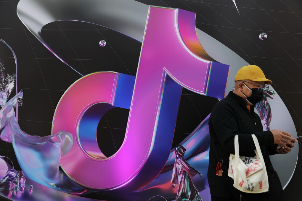 A man stands near a giant sign of ByteDance’s app Douyin during China Fashion Week in Beijing on March 31. Photo: Reuters