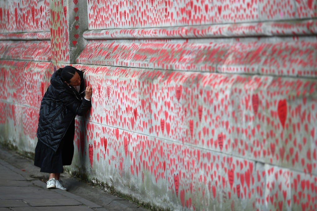 A person writes a message on the National Covid Memorial Wall in London, for those who have died in the UK. File photo: Reuters