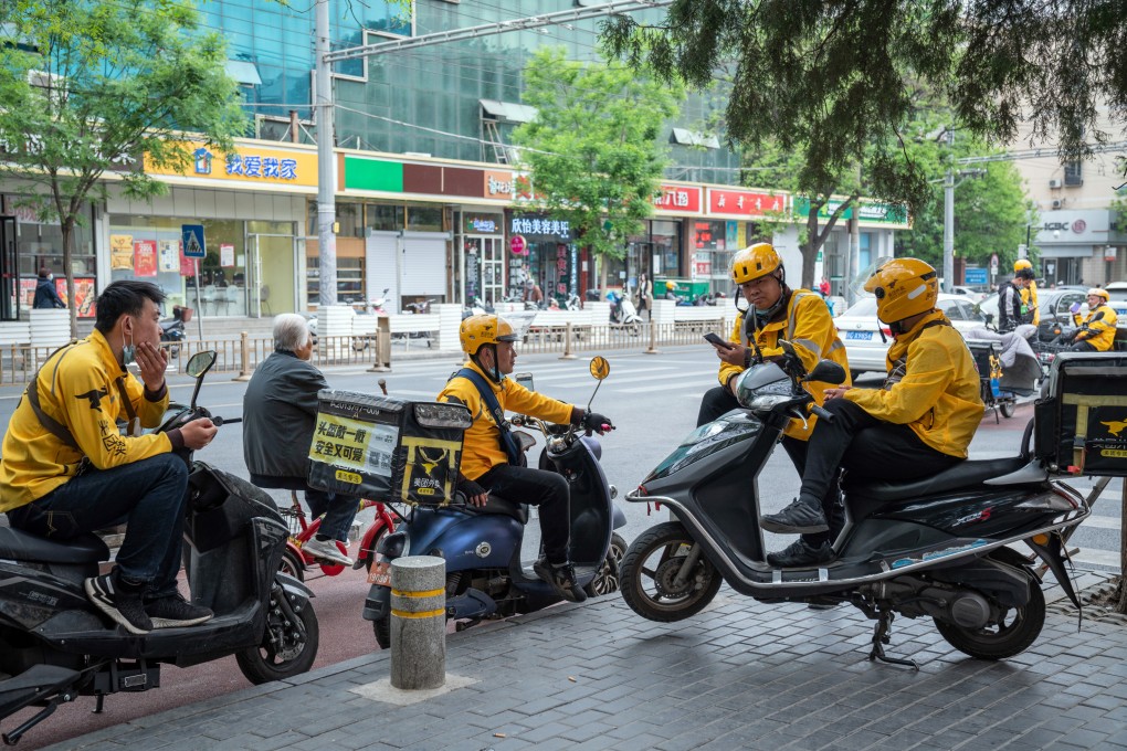 Food delivery couriers for Meituan gather around motorcycles in Beijing on April 21. The Chinese delivery giant is being investigated by Beijing over allegations that it forced merchants to exclusively sell on its platform, the same practice that resulted in Alibaba being fined US$2.8 billion. Photo: Bloomberg