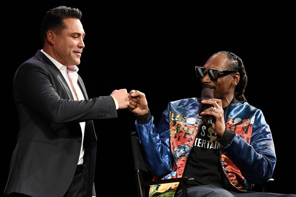 Golden Boy Promotions chairman and CEO Oscar De La Hoya (left) is greeted onstage by rapper Snoop Dogg during a news conference for Triller Fight Club. Photo: AFP
