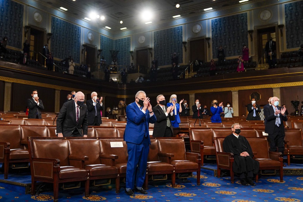 Senate Majority Leader Chuck Schumer stands and applauds as President Joe Biden addresses a joint session of Congress. Photo: AP