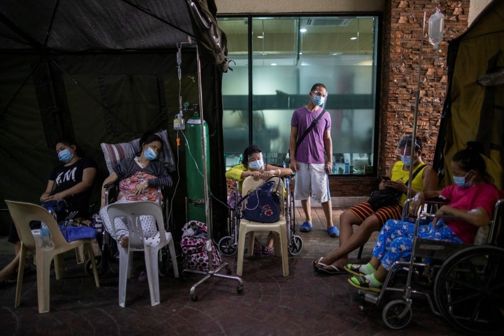 Patients are treated in wheelchairs amid a shortage of beds at a makeshift extension of a government hospital in Quezon City, the Philippines. Photo: Reuters