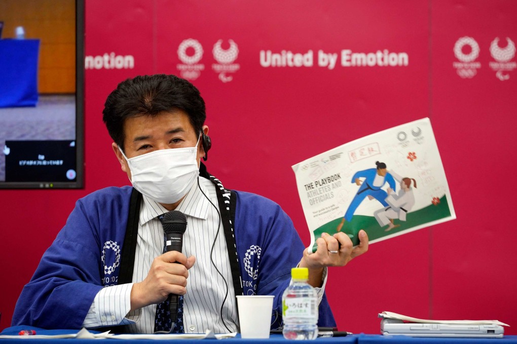 Tokyo 2020 Games Delivery Officer Hidemasa Nakamura holds version two of Tokyo 2020 Playbook. Photo: AFP
