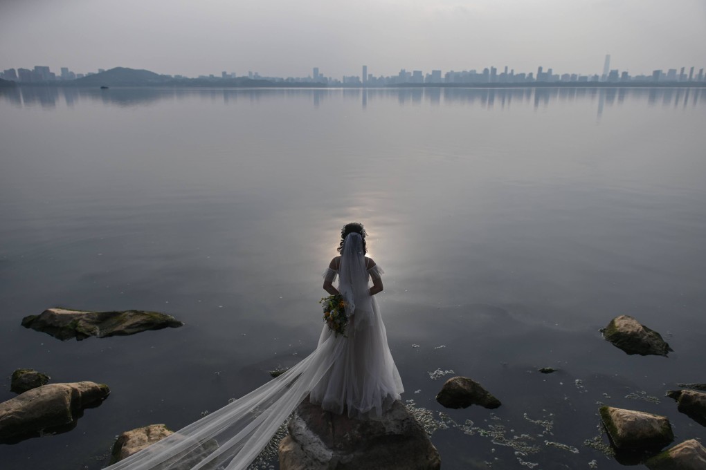 A bride poses for a wedding photographer next to East Lake in Wuhan, in central Hubei province, on April 19, 2020. The new divorce law is another example of the Chinese government’s intervention in family matters. Photo: AFP