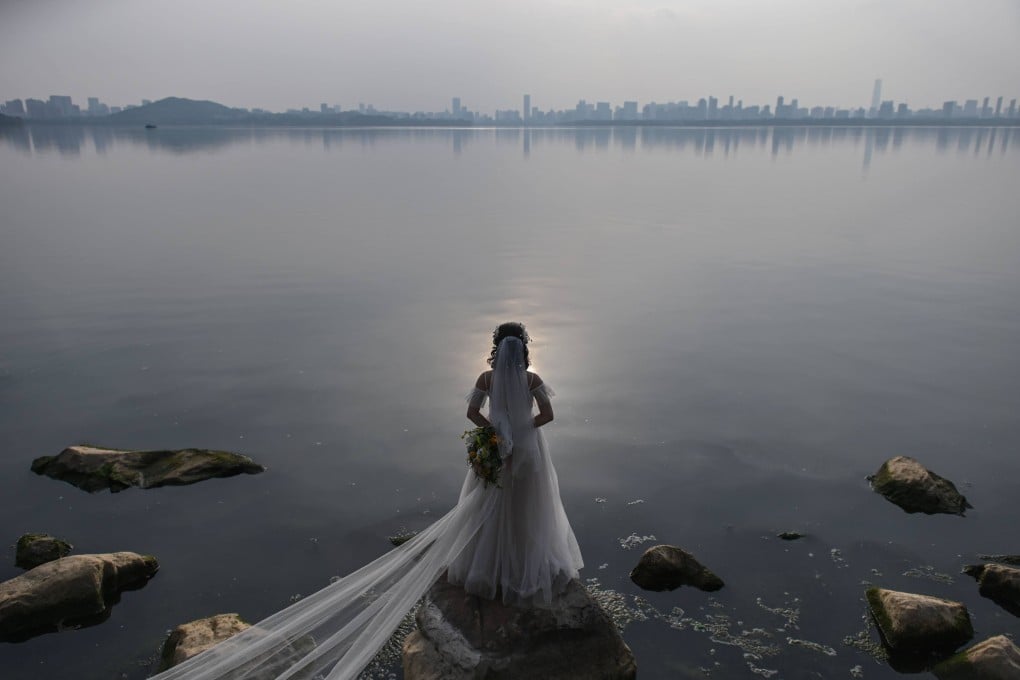 A bride poses for a wedding photographer next to East Lake in Wuhan, in central Hubei province, on April 19, 2020. The new divorce law is another example of the Chinese government’s intervention in family matters. Photo: AFP