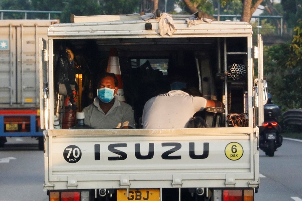 Migrant workers sit in the back of a lorry in Singapore. File photo: Reuters