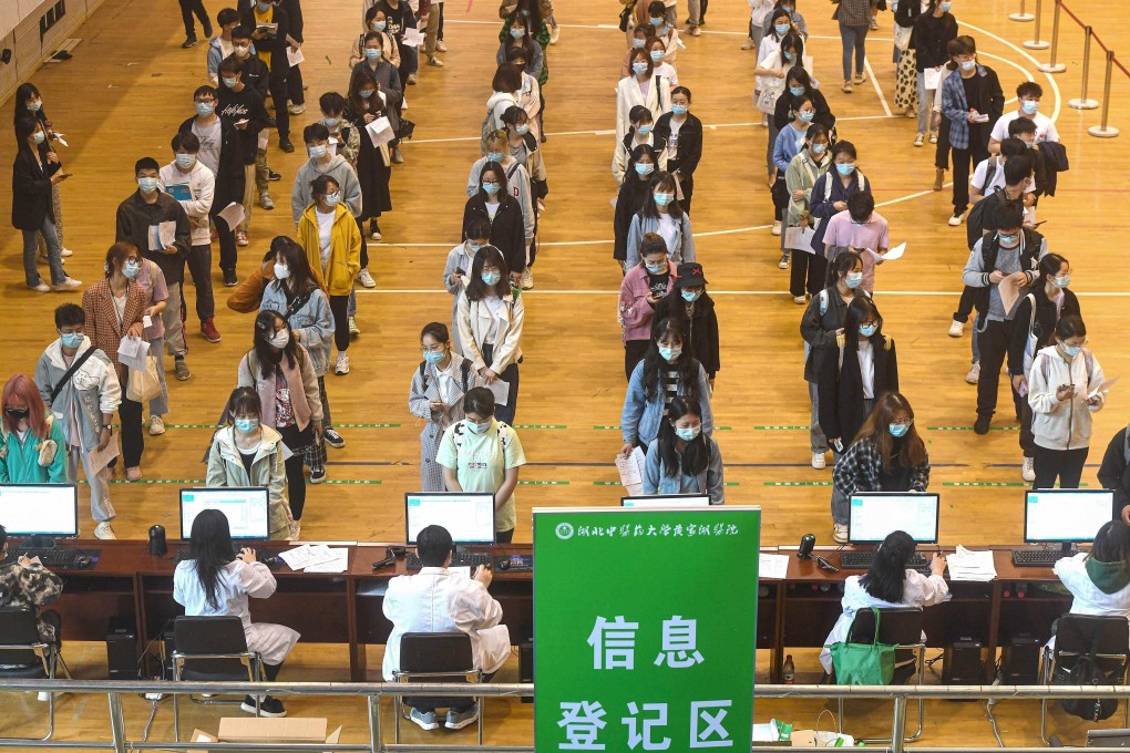 University students in Wuhan queue to receive Sinopharm Covid-19 jabs, but experts say not enough people are being vaccinated nationally. Photo: AFP