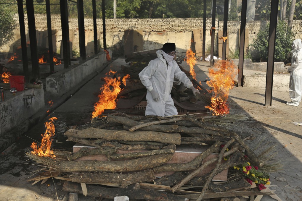 A family member performs the last rites of a Covid-19 victim at a crematorium in Jammu, India. Photo: AP