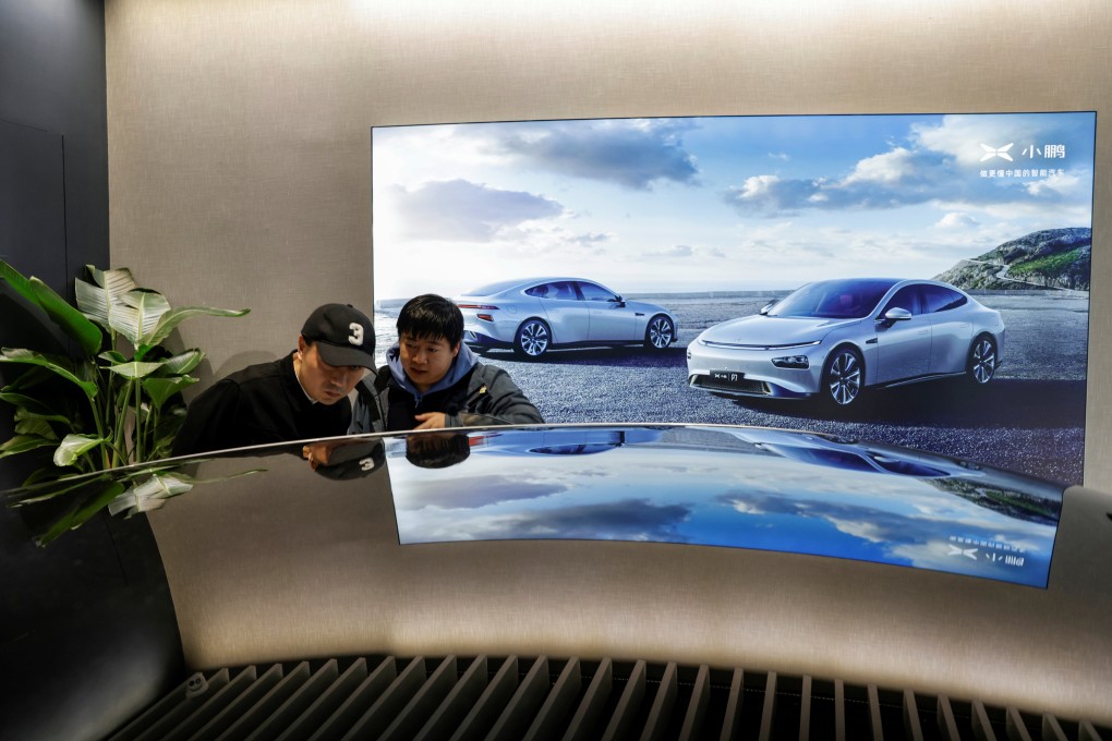Customers look at an XPeng electric car at a company store in Shanghai, March 11, 2021. Photo: Reuters