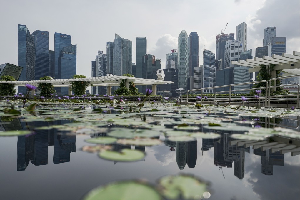 Singapore’s financial district skyline is seen reflected in a lotus pond on April 28. Photo: EPA