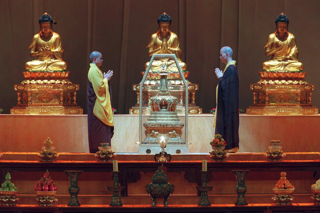 Two monks pay their respects along with thousands of devotees at the Hong Kong Coliseum following the arrival of the sacred Buddha’s tooth relic from Beijing.