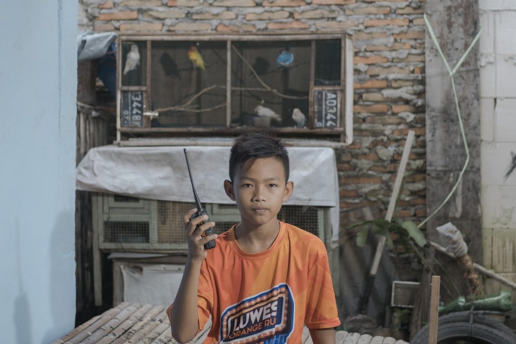 Fahri Yulianto, 11, listens to school lessons using a walkie-talkie in Surakarta, Indonesia. “At first, my teacher announced that we would study at home for two weeks, not expecting that it would be extended to more than a year until now. I’m looking forward to school reopening soon,” he says. Photo: Agoes Rudianto