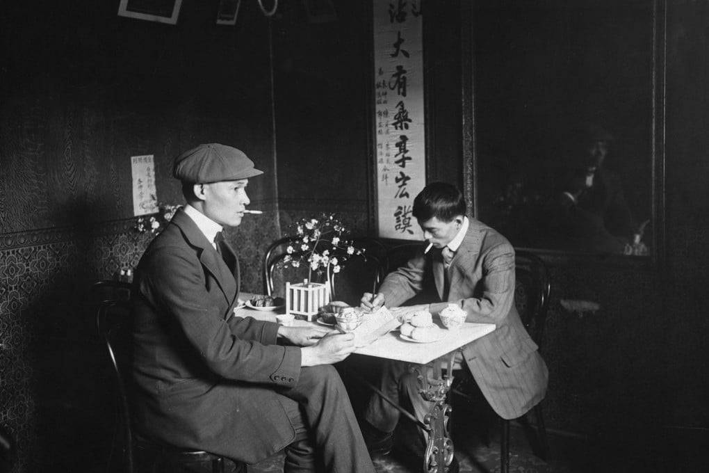 Two men smoke cigarettes as they sit at a table in Chinatown, London, in this undated photograph. Photo: Getty Images