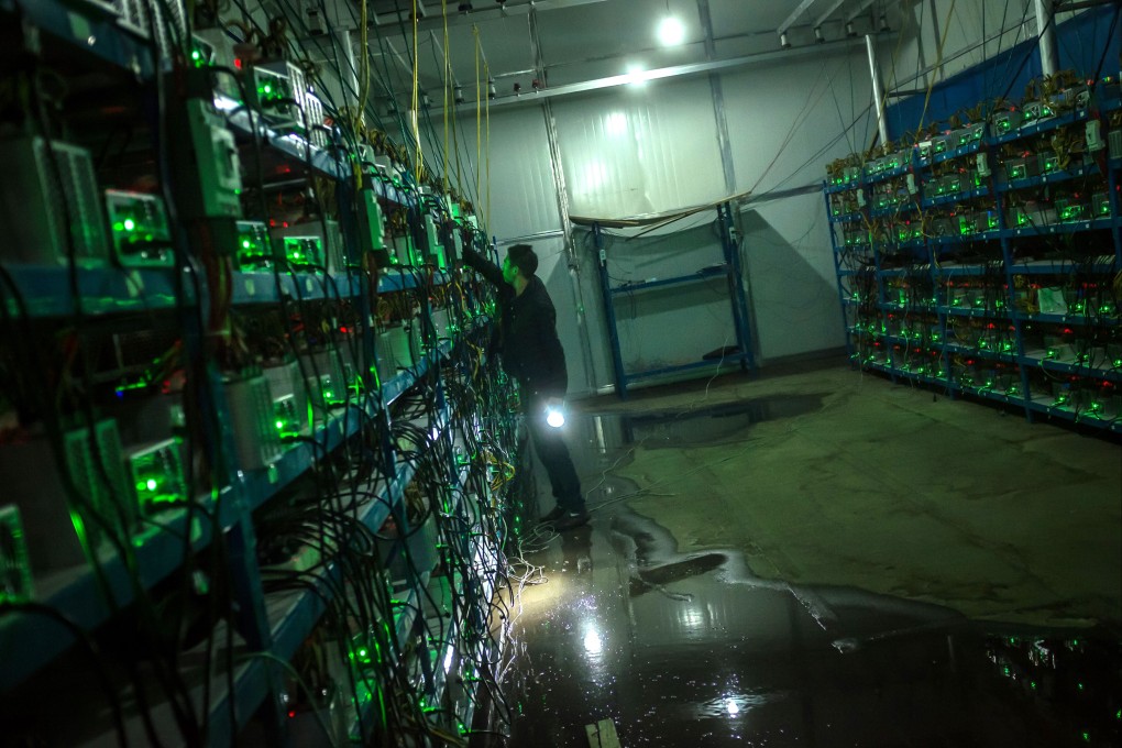 A bitcoin miner inspects a malfunctioning mining machine during his night shift at a facility in Sichuan province on September 26, 2016. While China is home to most of the bitcoin network’s computational power, Beijing has been cracking down mining recently over concerns related to financial stability and energy use. Photo: EPA